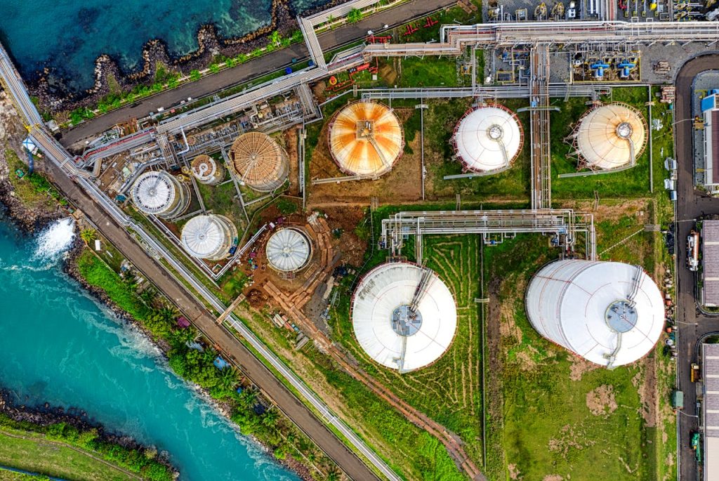 infrastructure-near-river-6754763 Aerial view of an industrial complex near a river in Banten, Indonesia, showcasing storage tanks.